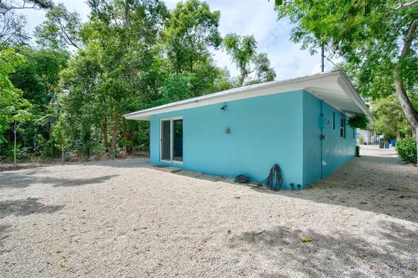 a backyard of a house with large trees and garage