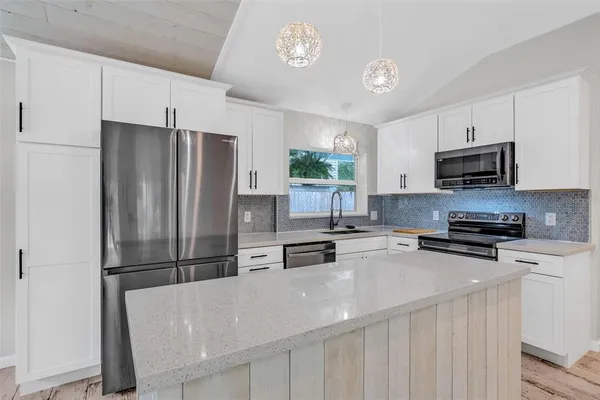 a kitchen with stainless steel appliances a refrigerator stove microwave and sink