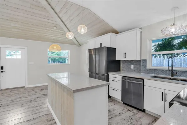 a kitchen that has a lot of cabinets a sink and a stove in it