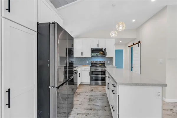 a kitchen with stainless steel appliances a refrigerator stove microwave and sink
