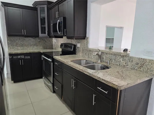 a kitchen with a stove microwave and sink