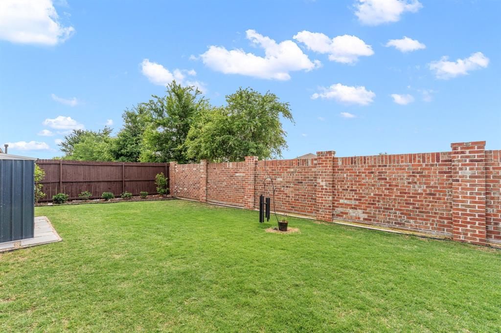 300 Copper Switch Drive Anna, TX 75409 - Photo 23 of 26 Backyard has wood side fencing and brick back wall