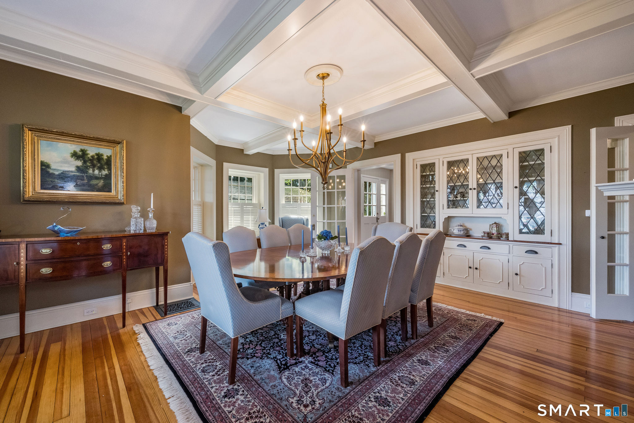 880 Boston Post Road Madison, CT 06443 - Photo 14 of 40 a dining room with wooden floor a chandelier a wooden table and chairs