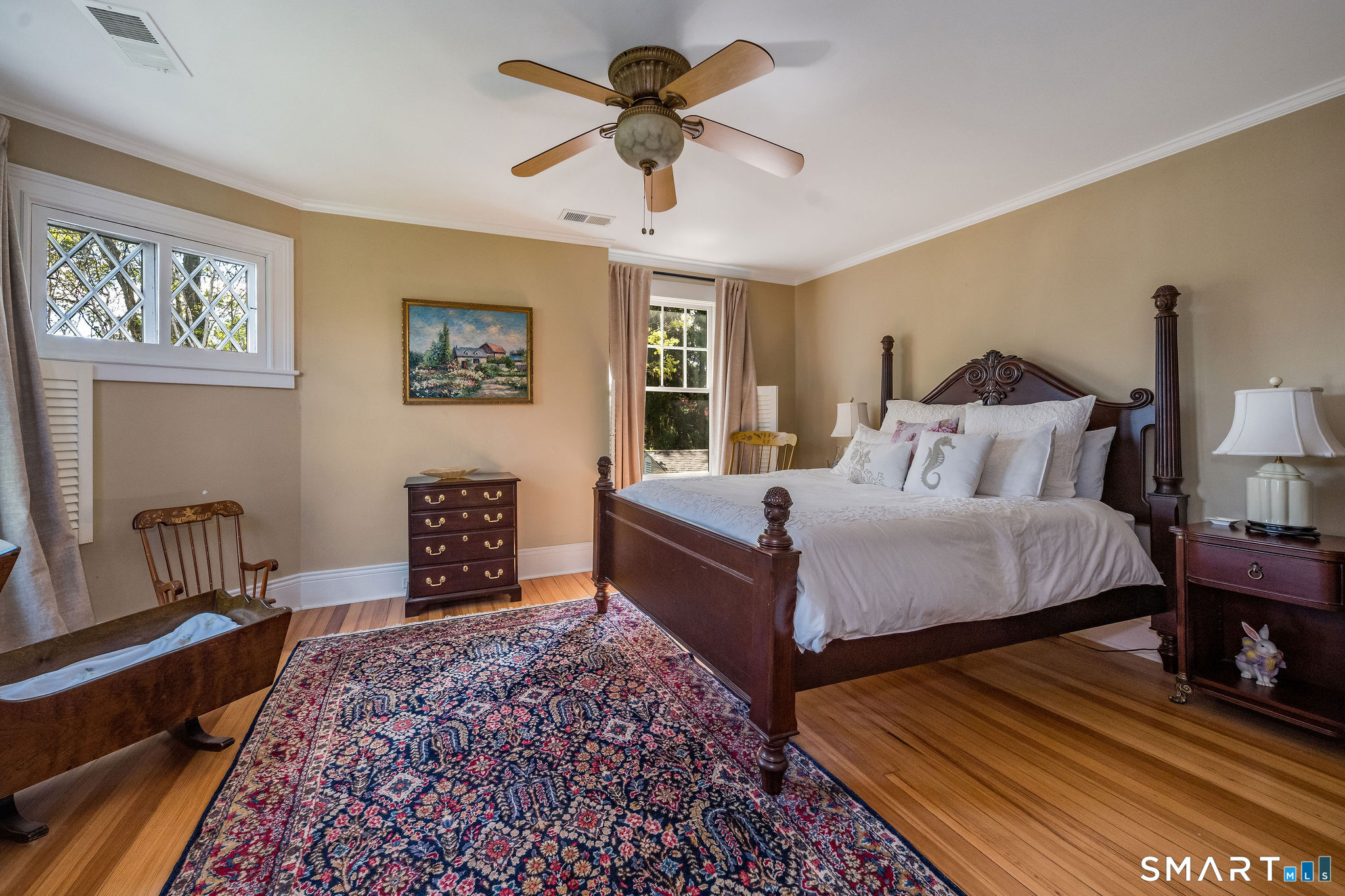 880 Boston Post Road Madison, CT 06443 - Photo 34 of 40 a spacious bedroom with a bed and a chandelier
