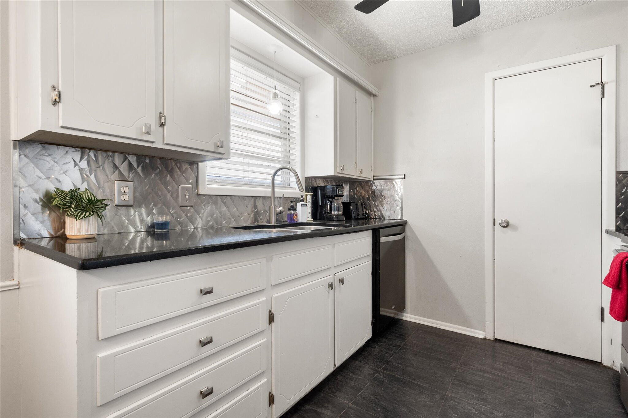 4803 8th Street Lubbock, TX 79416 - Photo 13 of 29 a kitchen with granite countertop white cabinets and window
