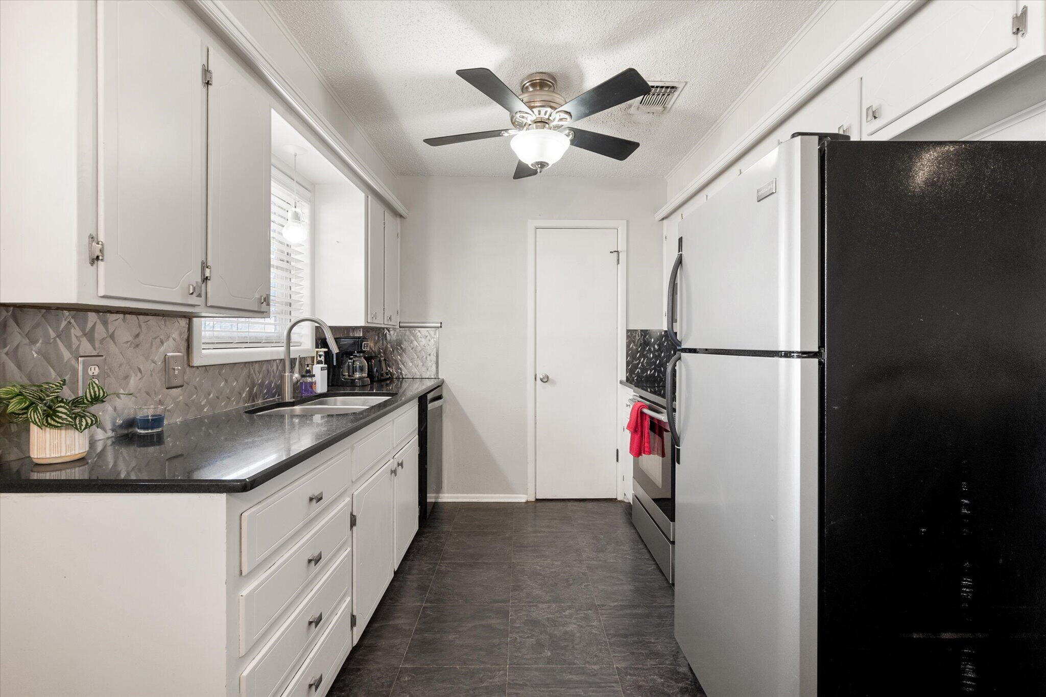 4803 8th Street Lubbock, TX 79416 - Photo 14 of 29 a kitchen with a refrigerator and a sink