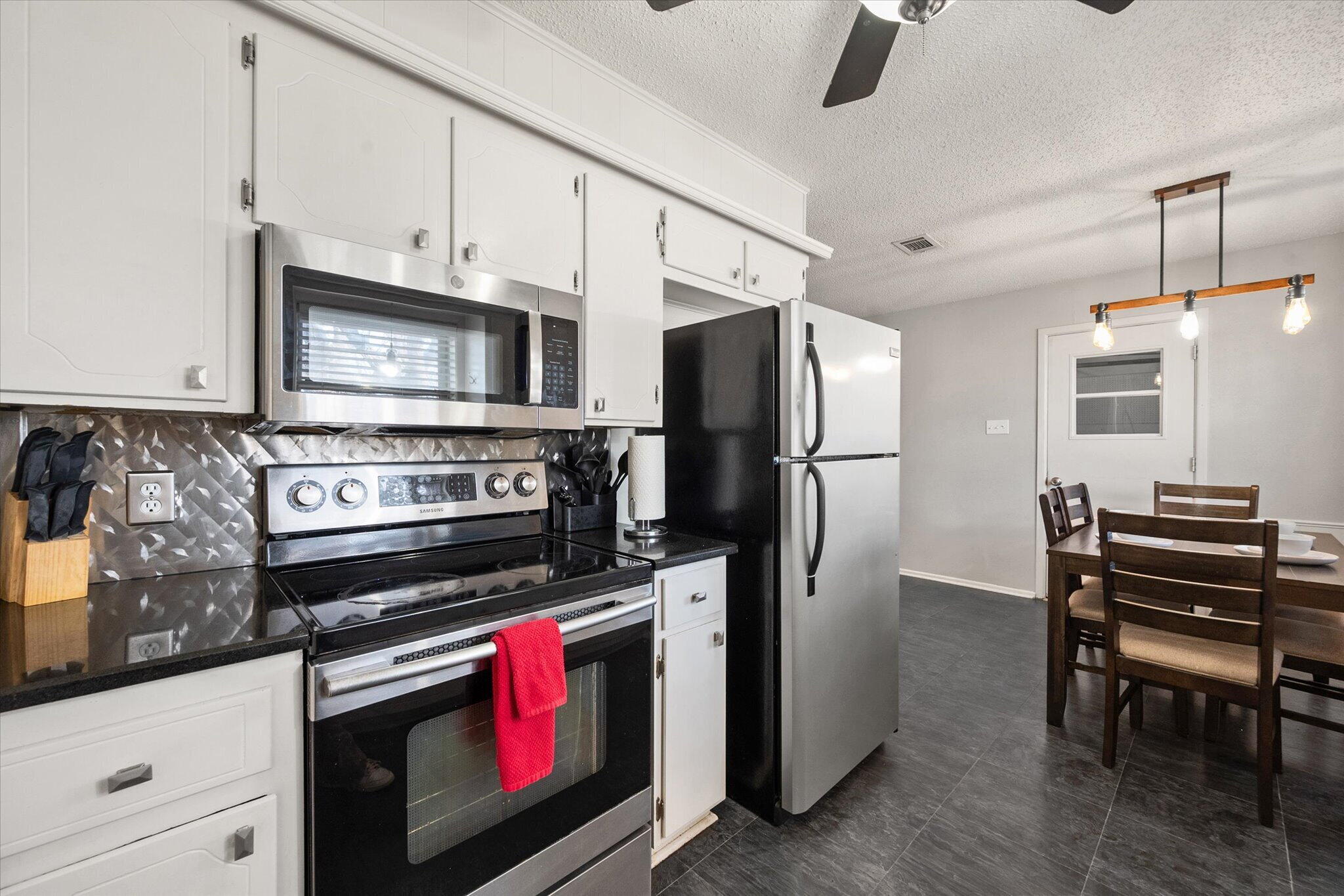 4803 8th Street Lubbock, TX 79416 - Photo 16 of 29 a kitchen with stainless steel appliances a stove a refrigerator and a fireplace