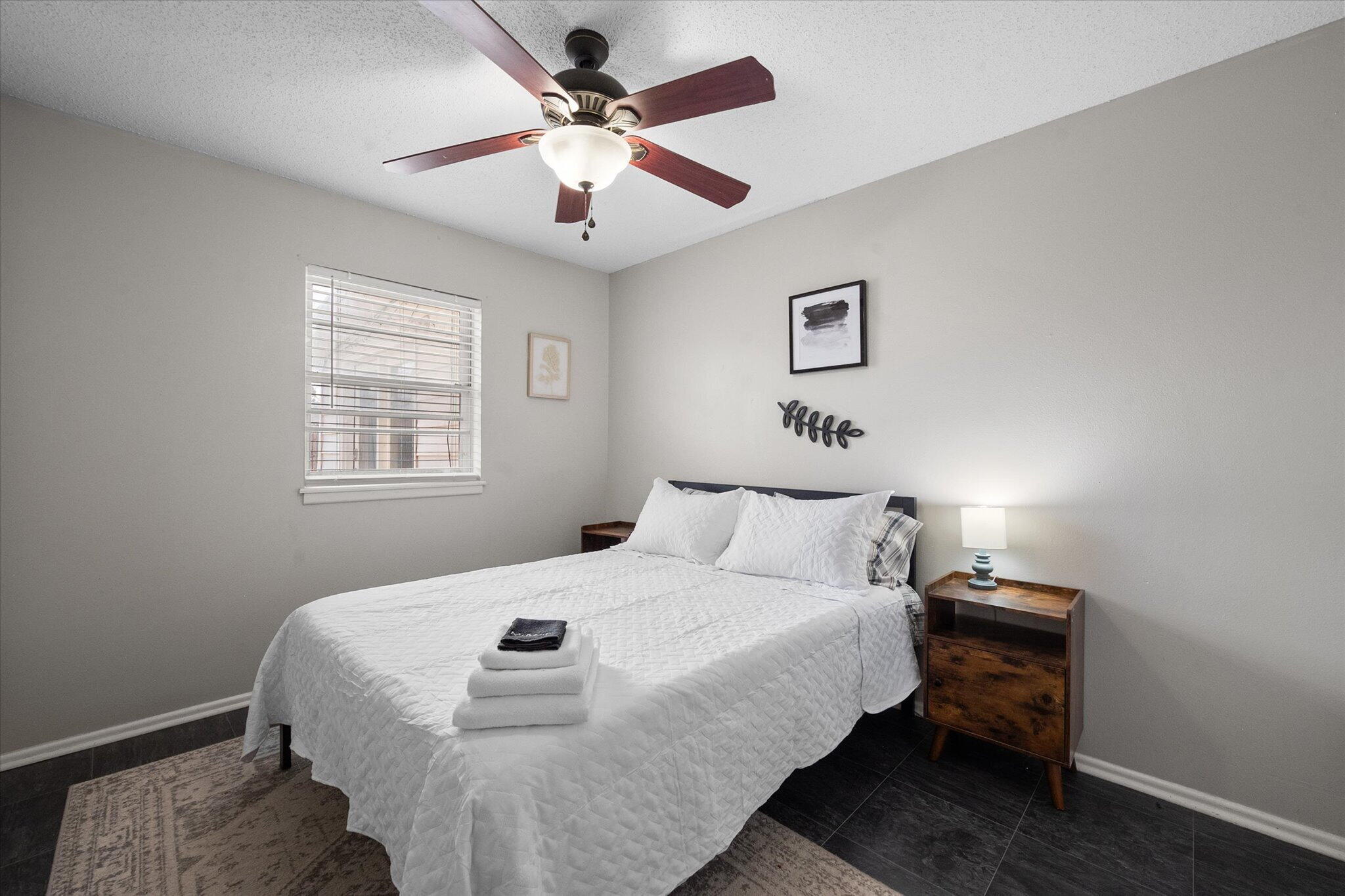 4803 8th Street Lubbock, TX 79416 - Photo 20 of 29 a bedroom with a bed and a chandelier