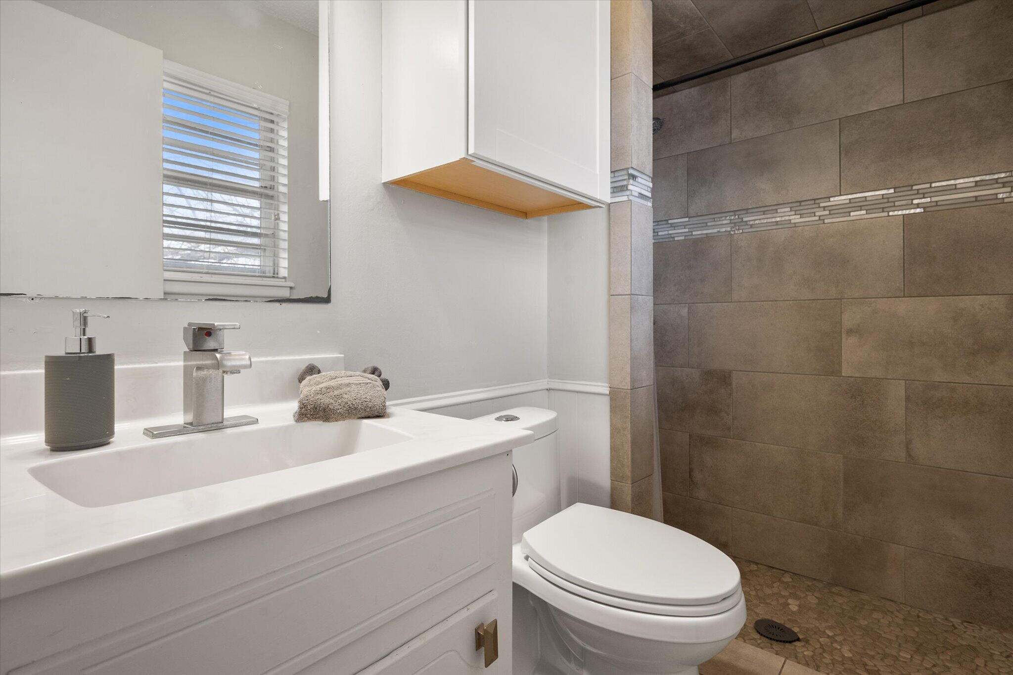4803 8th Street Lubbock, TX 79416 - Photo 24 of 29 a bathroom with a granite countertop sink a toilet and a mirror