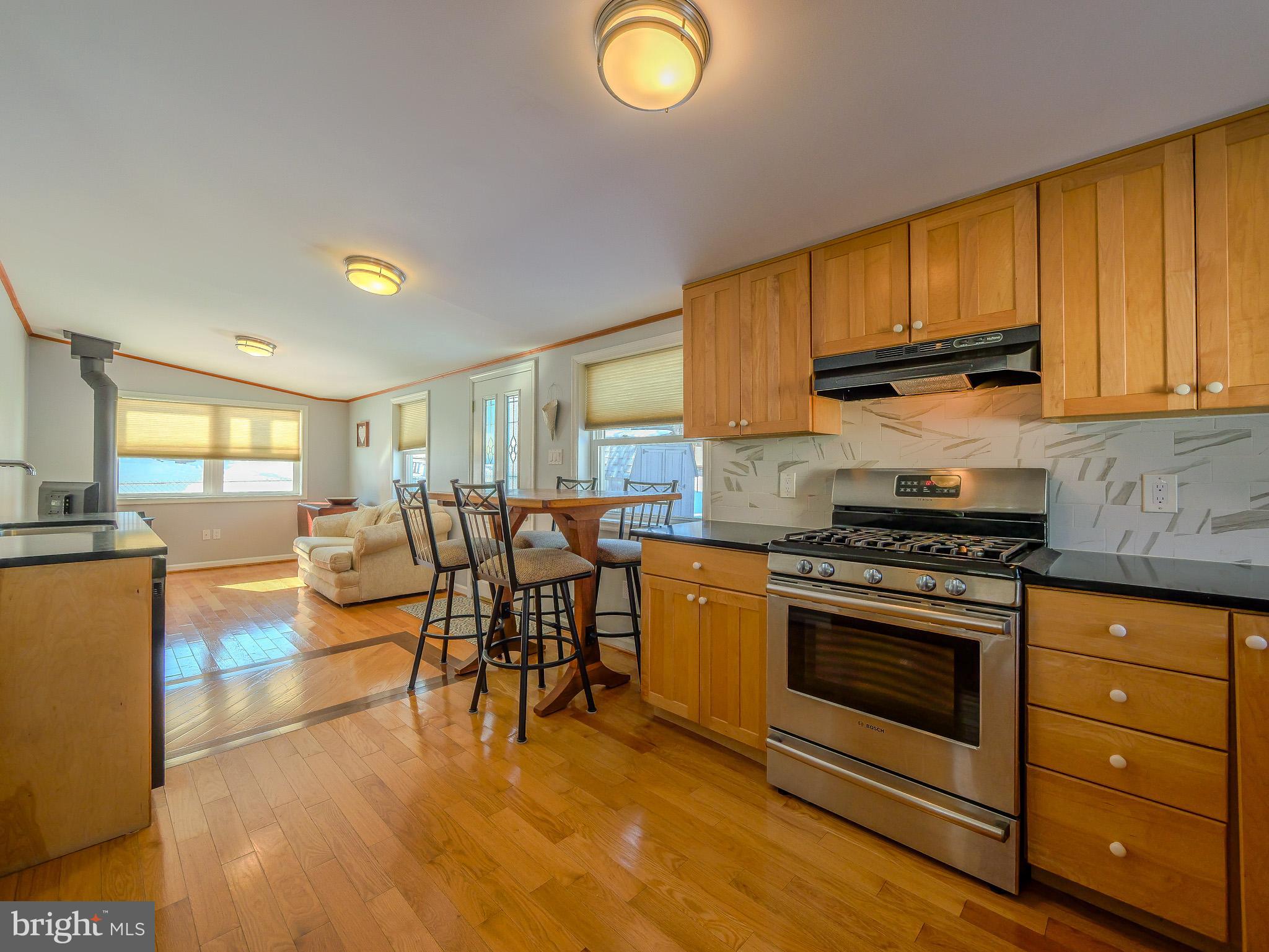 118 North Line Road Newtown Square, PA 19073 - Photo 20 of 69 a kitchen with stainless steel appliances granite countertop a stove top oven a sink dishwasher a dining table and chairs with wooden floor