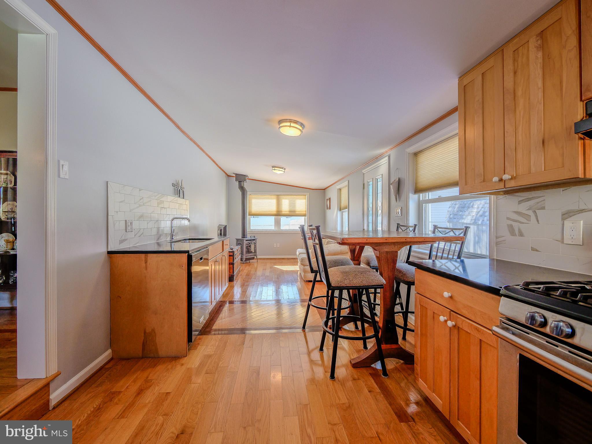 118 North Line Road Newtown Square, PA 19073 - Photo 22 of 69 a kitchen with stainless steel appliances granite countertop a stove top oven a sink a dining table and chairs with wooden floor