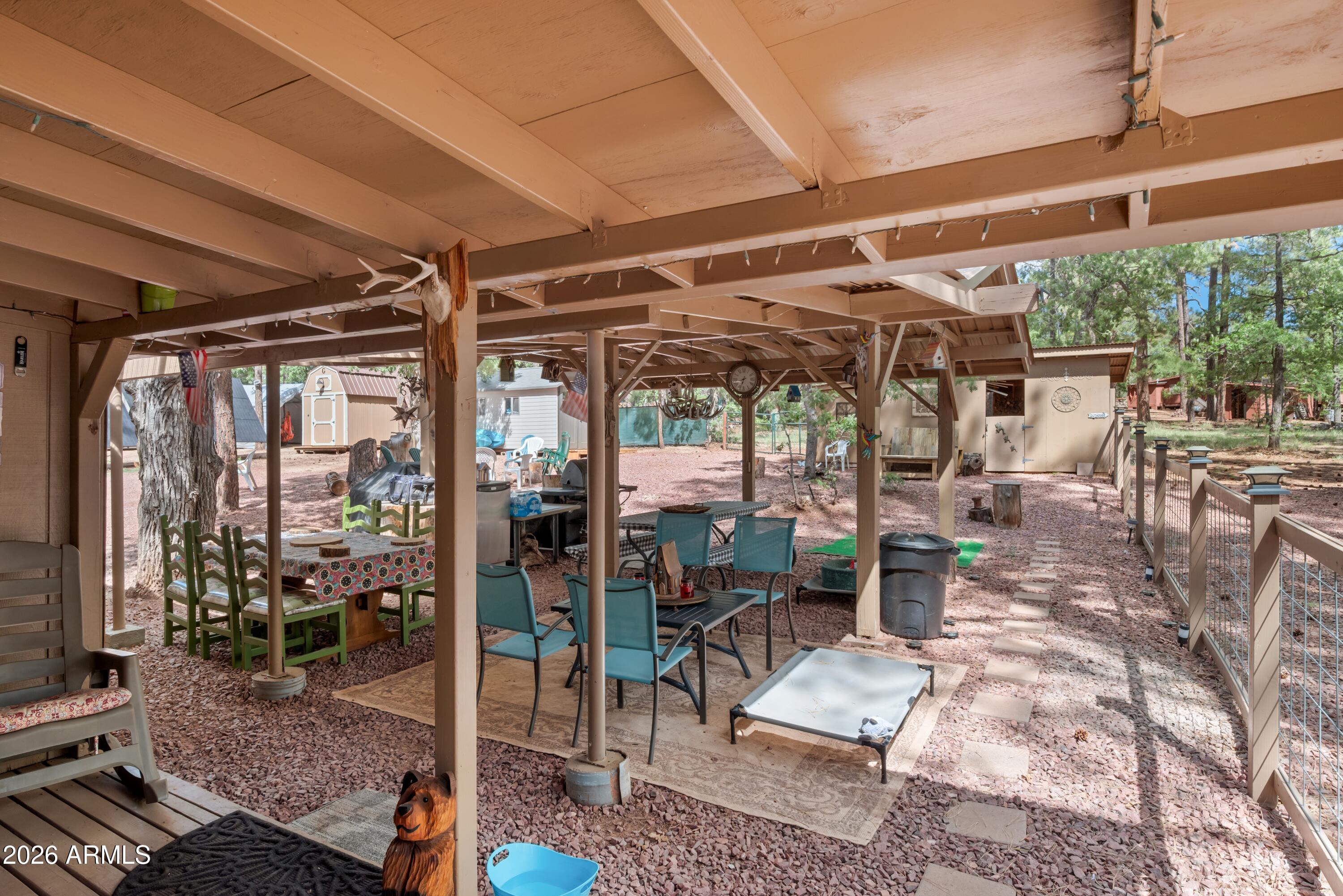 1659 Mormon Road Happy Jack, AZ 86024 - Photo 28 of 37 a view of a patio with table and chairs potted plants and floor to ceiling window