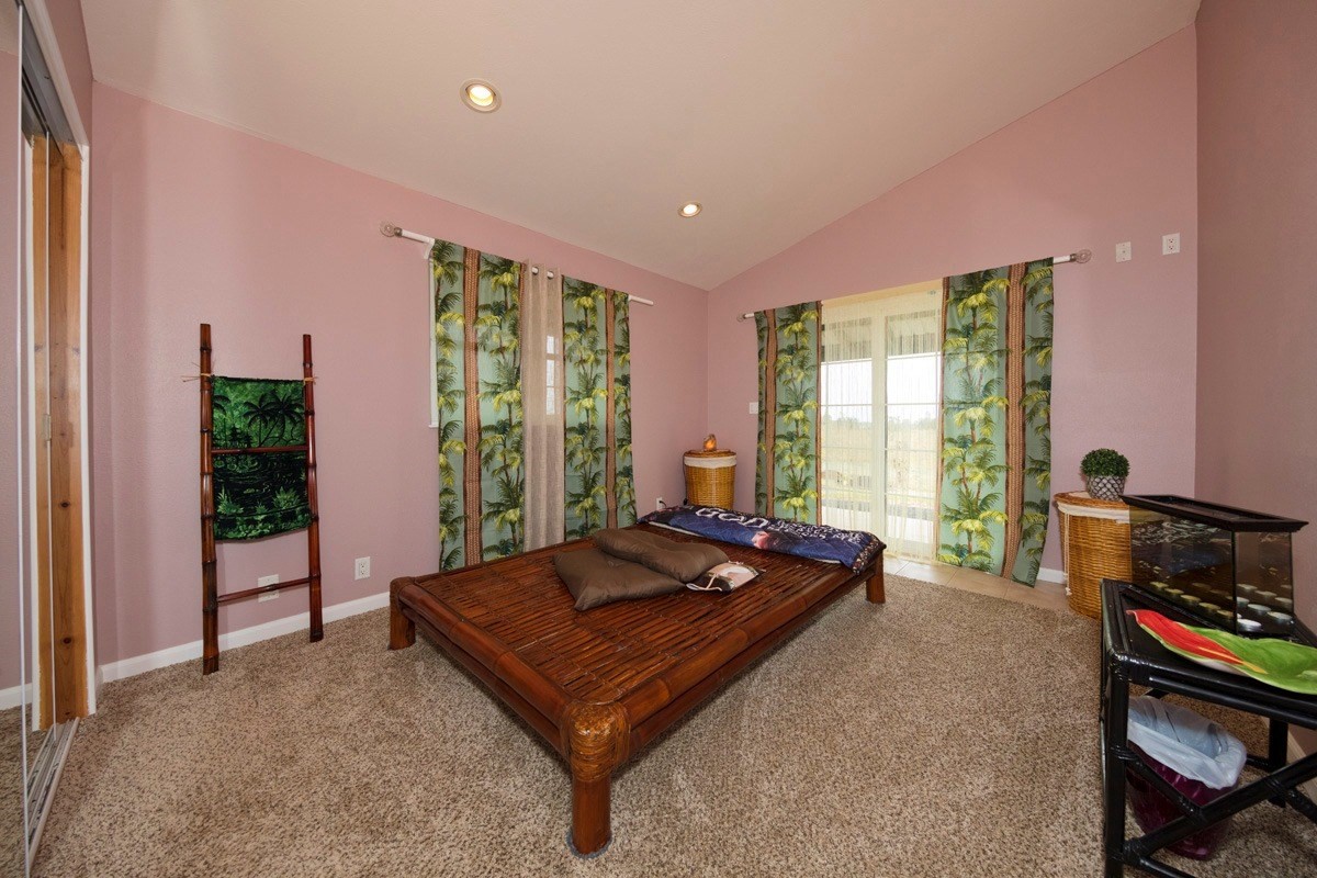 18-4235 North Pszyk Road Mountain View, HI 96771 - Photo 12 of 30 a living room with furniture a flat screen tv and large windows