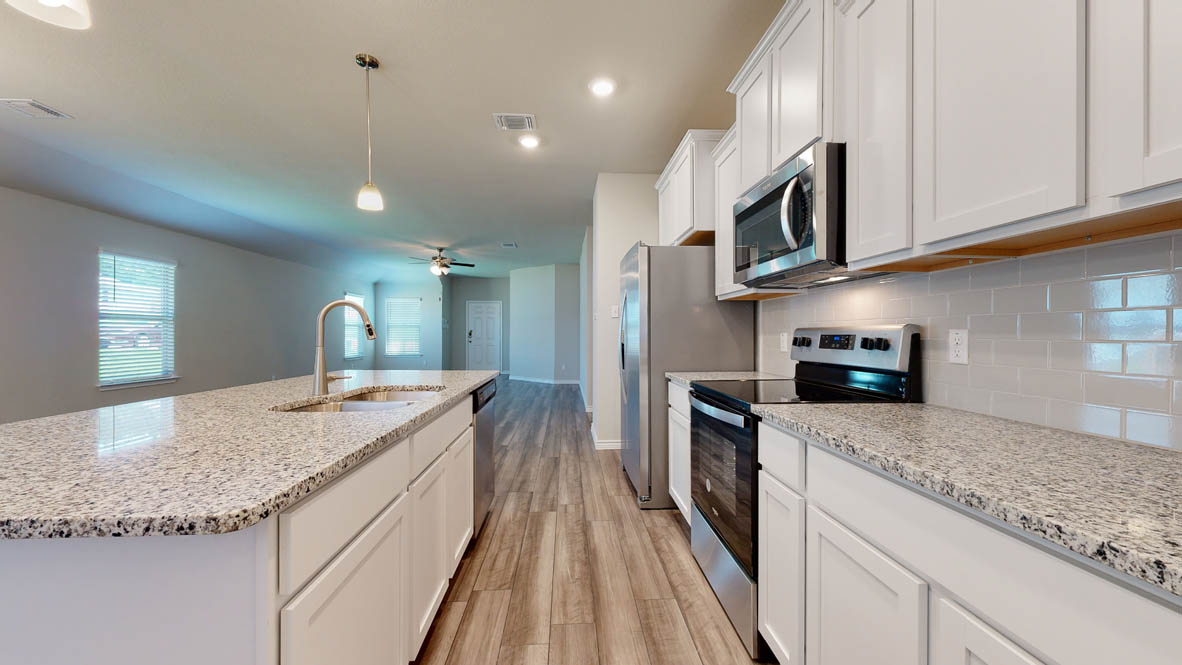 104 Kenzie Street Thorndale, TX 76577 - Photo 5 of 28 a kitchen with stainless steel appliances granite countertop a sink and stove