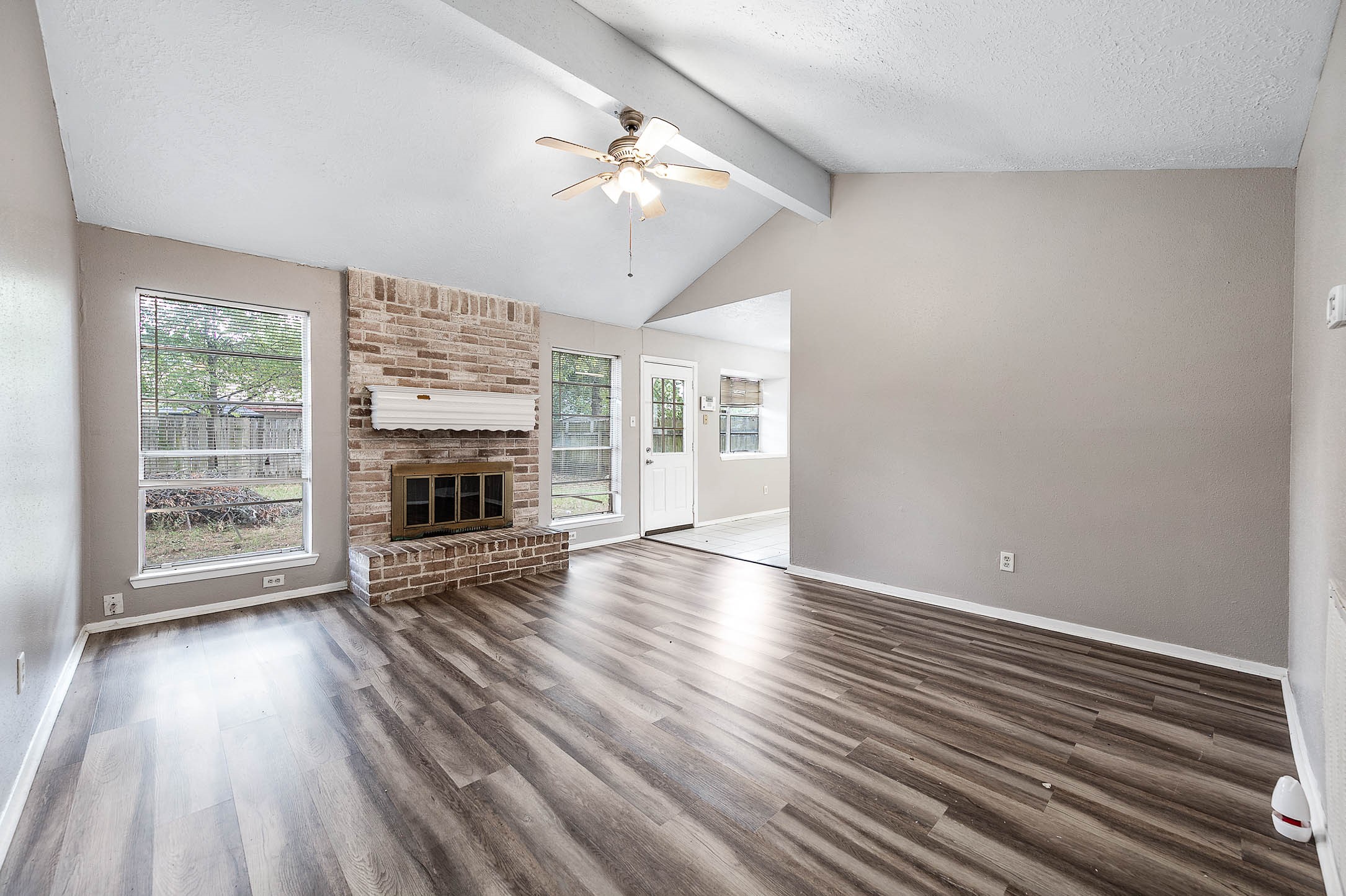 4918 Quailgate Drive Spring, TX 77373 - Photo 3 of 17 an empty room with wooden floor fireplace and windows