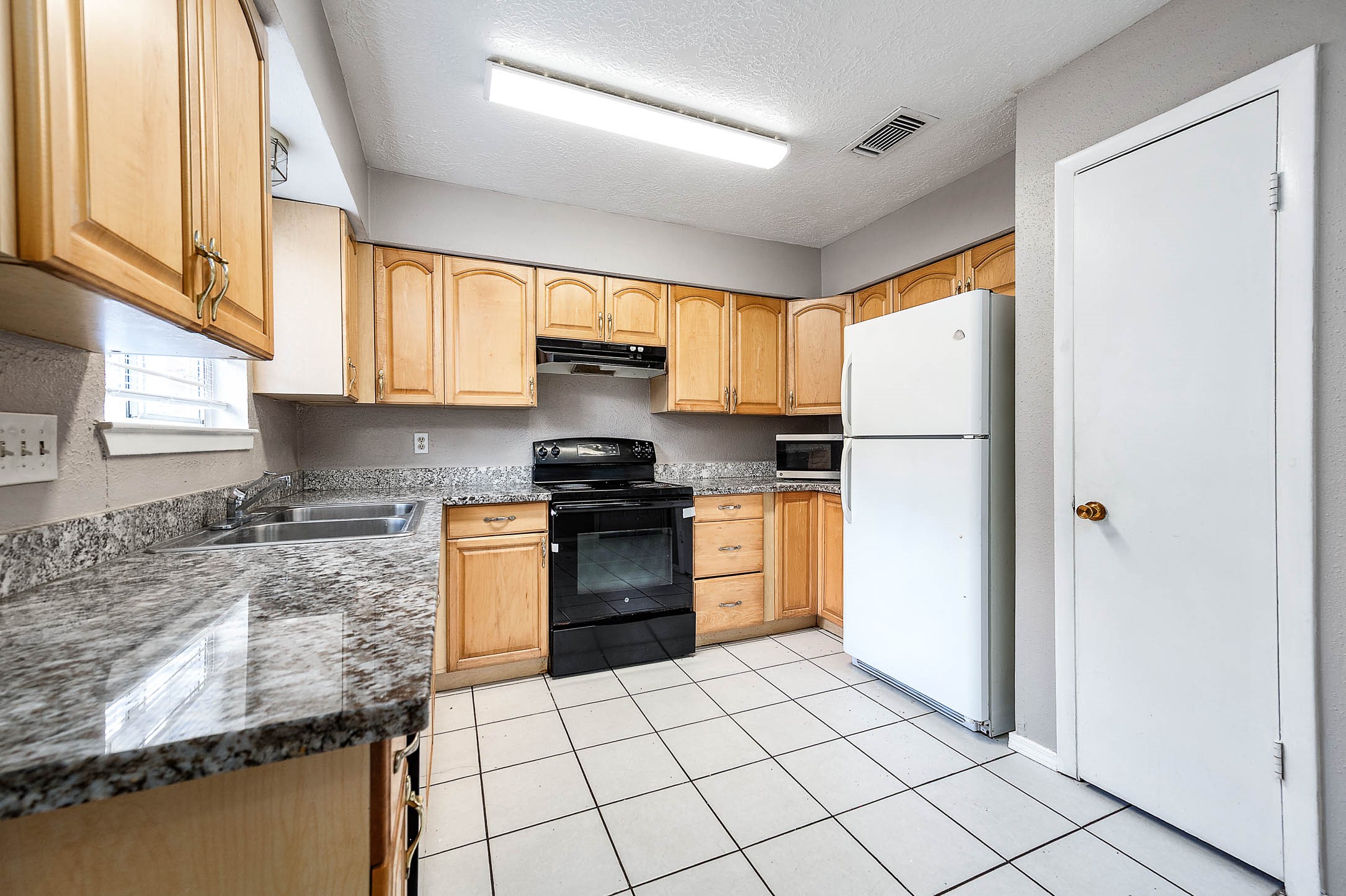 4918 Quailgate Drive Spring, TX 77373 - Photo 7 of 17 a kitchen with a refrigerator sink and cabinets