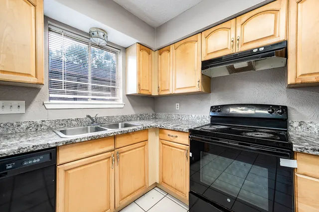 a kitchen with granite countertop a sink stainless steel appliances and cabinets