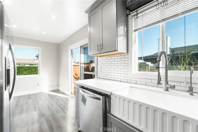 a kitchen with stainless steel appliances granite countertop a sink a stove and a wooden floors