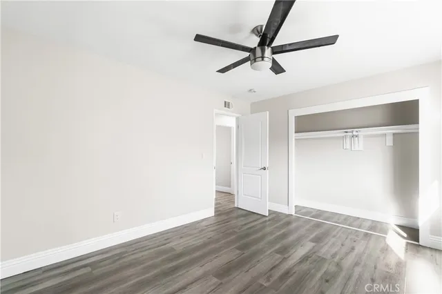 a view of a room with wooden floor and a ceiling fan