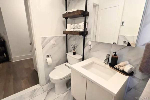 a bathroom with a granite countertop toilet sink and mirror