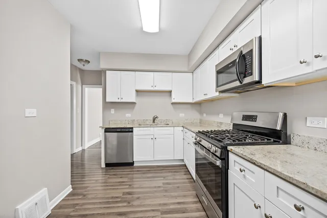 a kitchen with stainless steel appliances granite countertop a stove and a sink