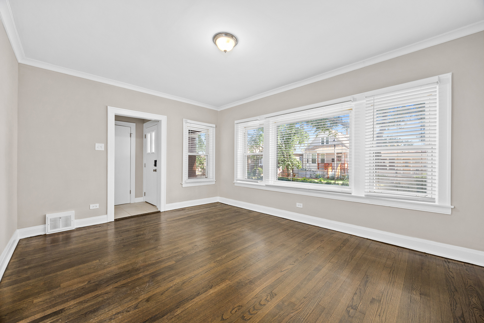 6535 26th Place Berwyn, IL 60402 - Photo 6 of 26 a view of an empty room with wooden floor and a window