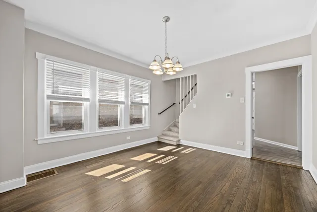 a view of a room with wooden floor staircase and a chandelier