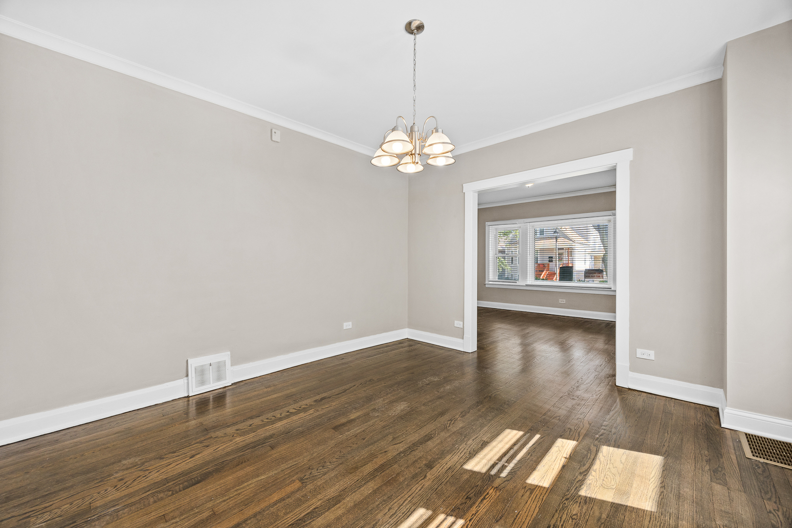 6535 26th Place Berwyn, IL 60402 - Photo 9 of 26 a view of a room with wooden floor chandelier and a window