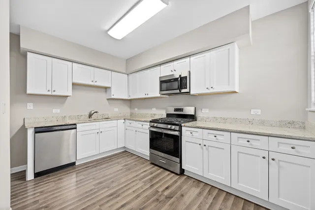 a kitchen with granite countertop white cabinets and white appliances