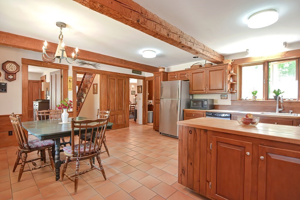 244 Davis Road Ashby, MA 01431 - Photo 14 of 35 a kitchen with a table chairs refrigerator and cabinets