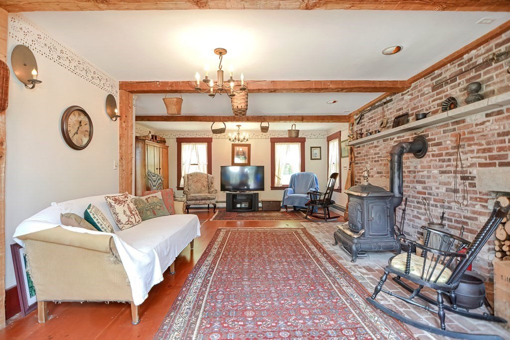 244 Davis Road Ashby, MA 01431 - Photo 9 of 35 a living room with furniture a fireplace and a chandelier
