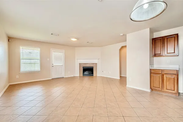 an empty room with windows and fireplace