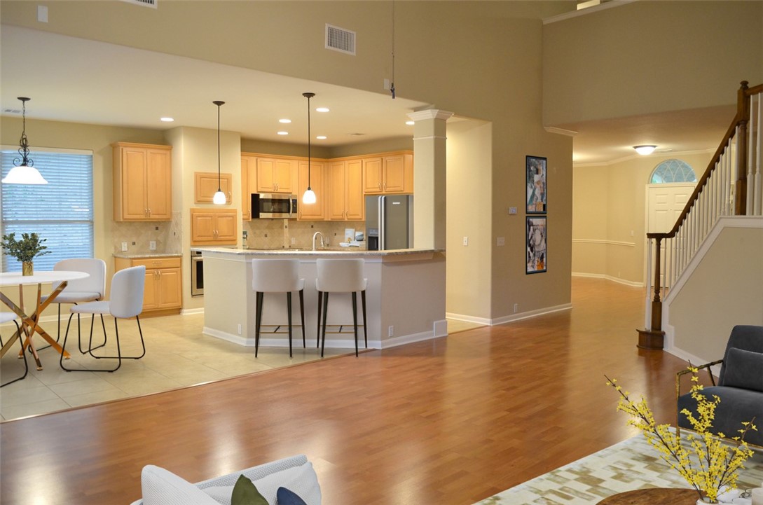 a room with stainless steel appliances kitchen island granite countertop furniture and a view of living room