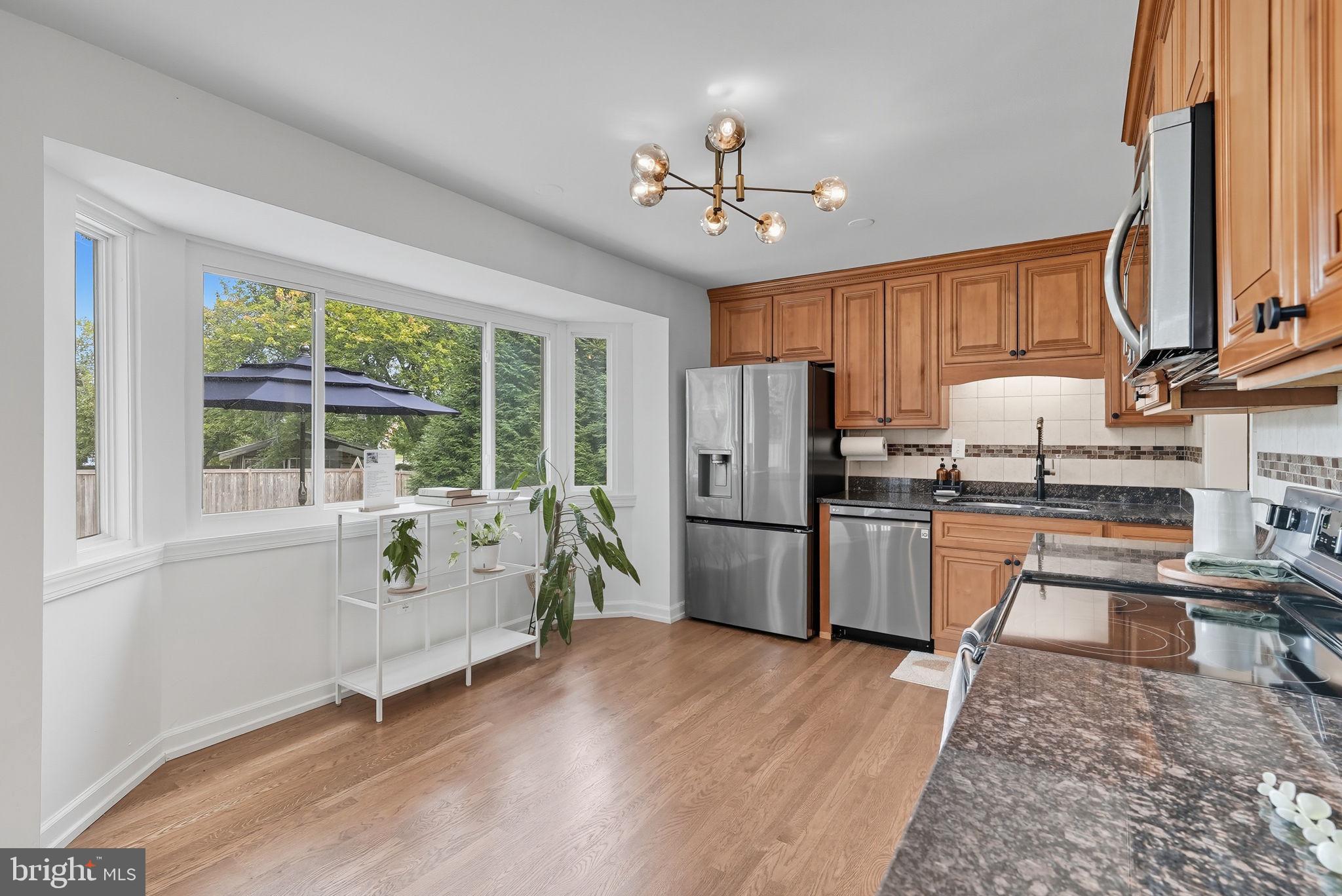 2411 Lillian Drive Silver Spring, MD 20902 - Photo 11 of 48 a kitchen with refrigerator a stove a sink and dishwasher with wooden floor