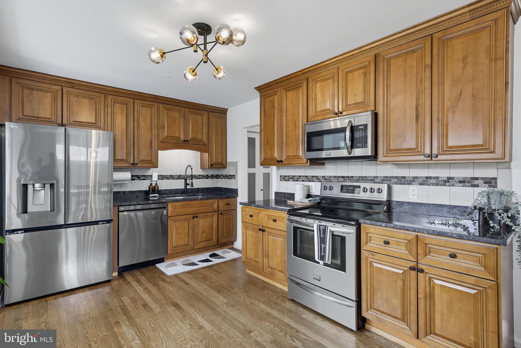 2411 Lillian Drive Silver Spring, MD 20902 - Photo 10 of 48 a kitchen with stainless steel appliances granite countertop a refrigerator stove microwave and sink
