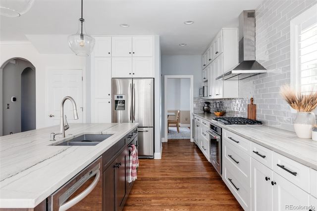 a kitchen with stainless steel appliances granite countertop a sink stove and refrigerator