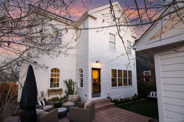 a front view of a house with barbeque grill and wooden fence