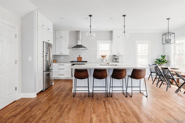 a kitchen with stainless steel appliances kitchen island a table and chair in it