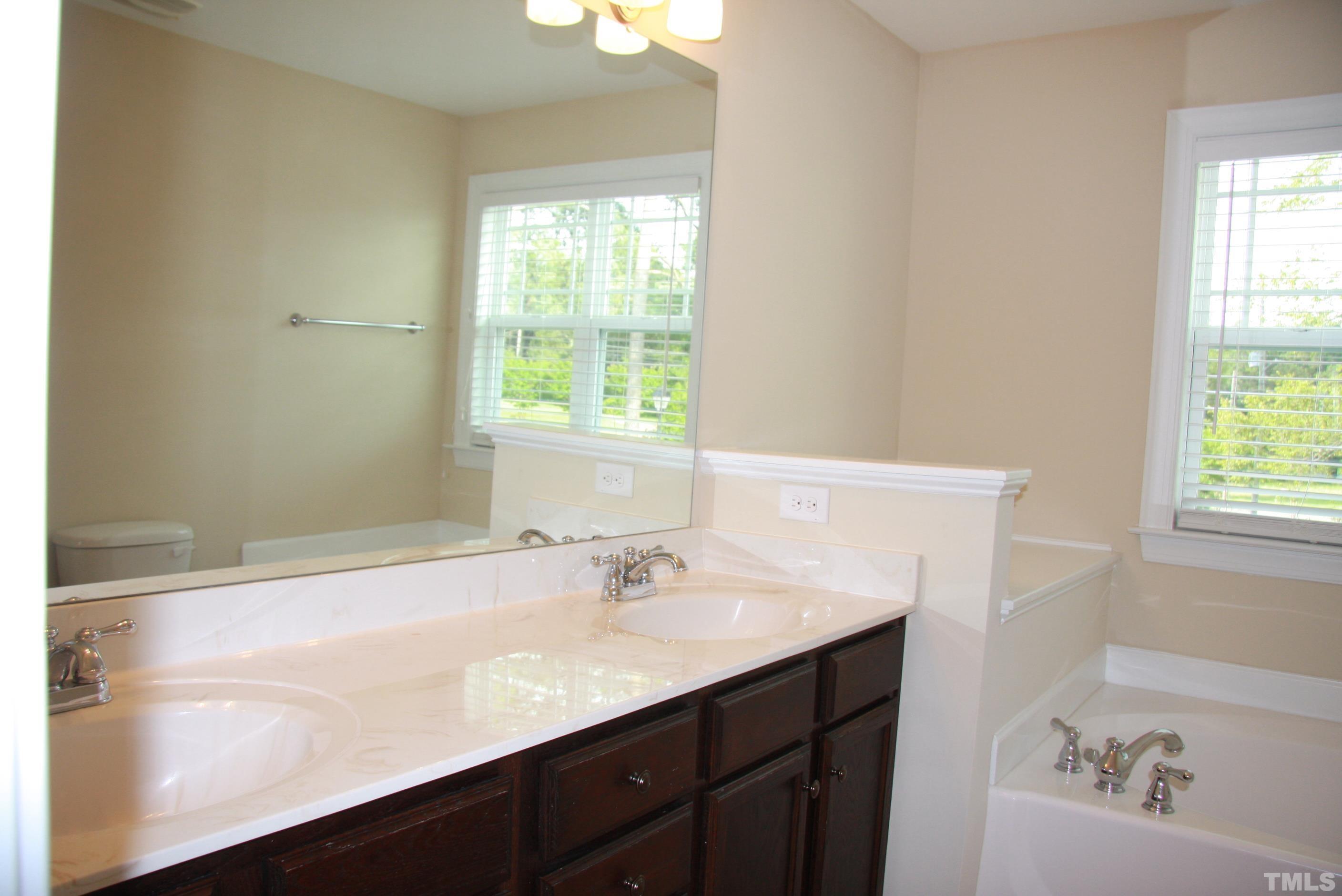 2021 Chancellor Place Raleigh, NC 27603 - Photo 19 of 30 a bathroom with a sink a bathtub and a window