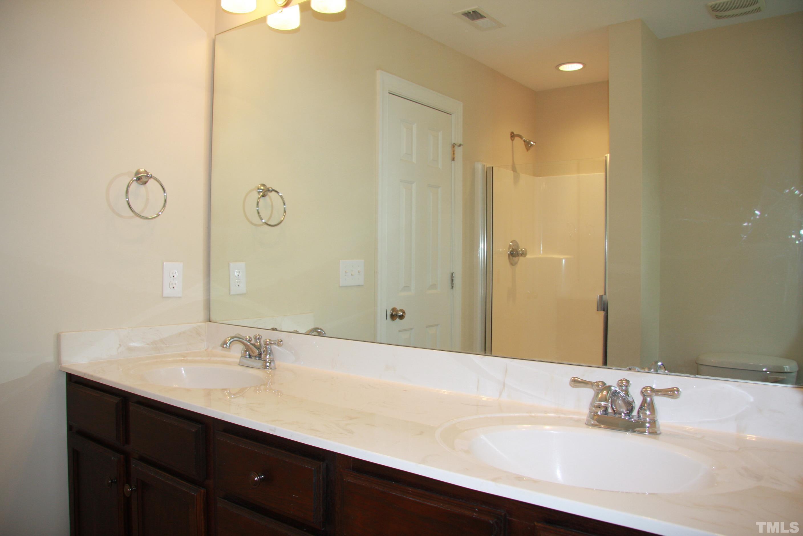 2021 Chancellor Place Raleigh, NC 27603 - Photo 20 of 30 a bathroom with a double vanity sink mirror and shower