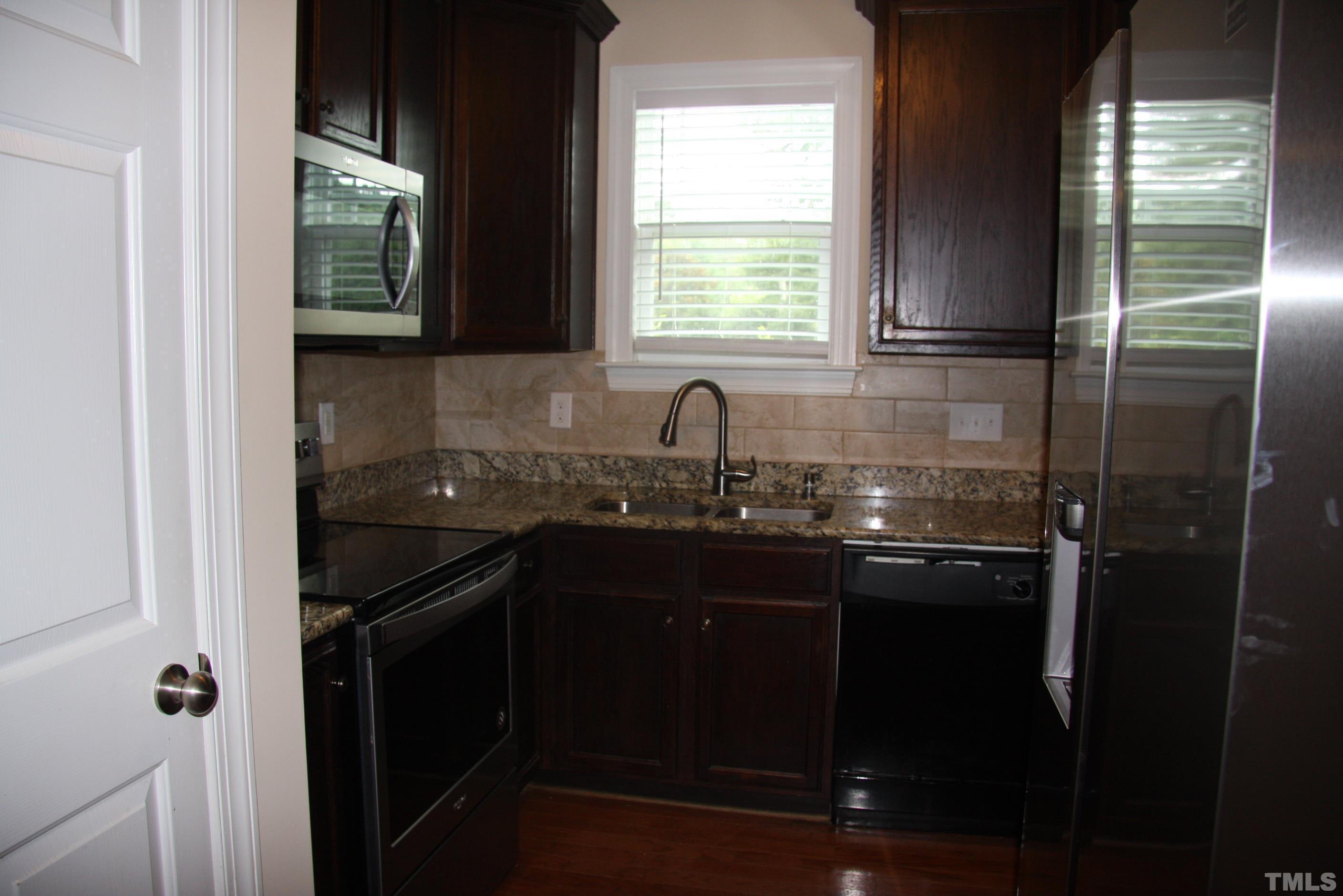 2021 Chancellor Place Raleigh, NC 27603 - Photo 8 of 30 a kitchen with a sink a window and cabinets