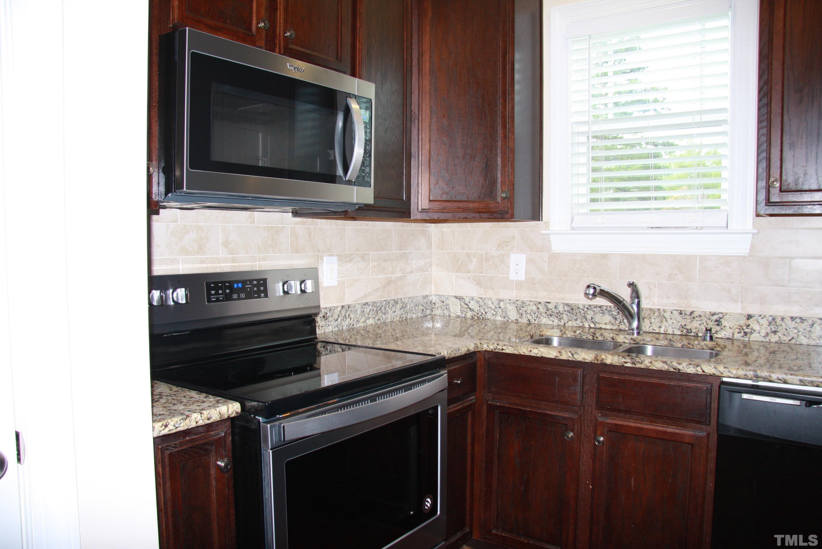 2021 Chancellor Place Raleigh, NC 27603 - Photo 9 of 30 a kitchen with granite countertop a stove microwave and sink