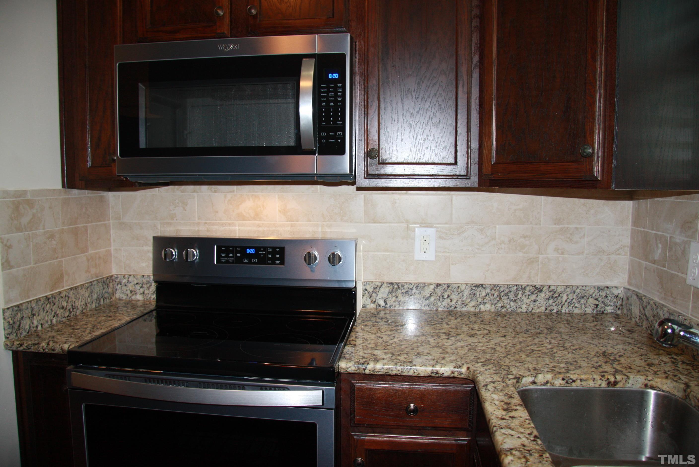 2021 Chancellor Place Raleigh, NC 27603 - Photo 10 of 30 a kitchen with granite countertop a stove and a microwave