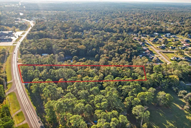 an aerial view of residential houses with outdoor space and trees