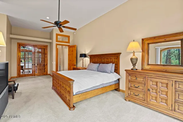 a bedroom with a large bed and a chandelier
