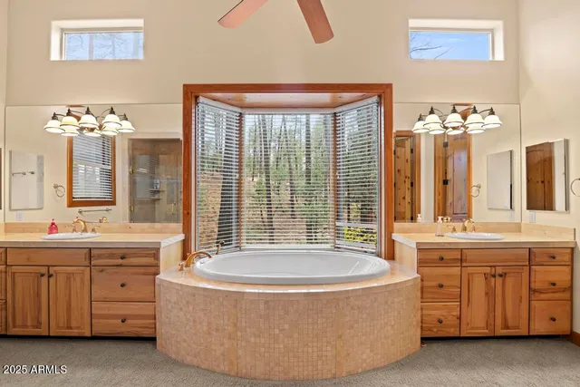 a spacious bathroom with a tub sink and mirror