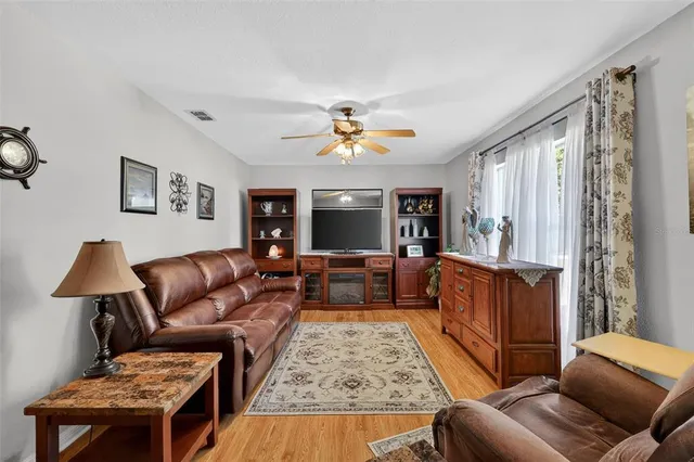 a living room with furniture ceiling fan and a rug