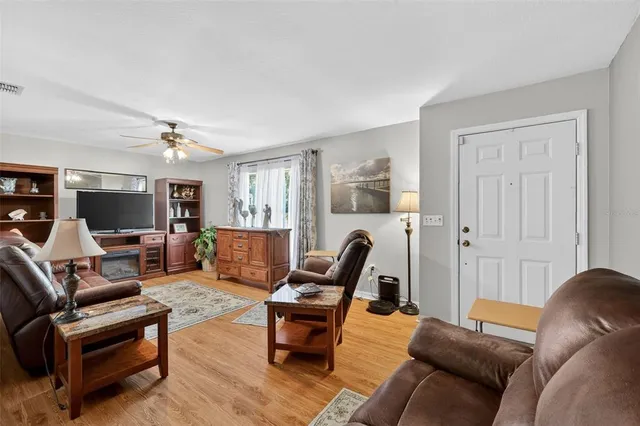 a living room with furniture a flat screen tv and a window