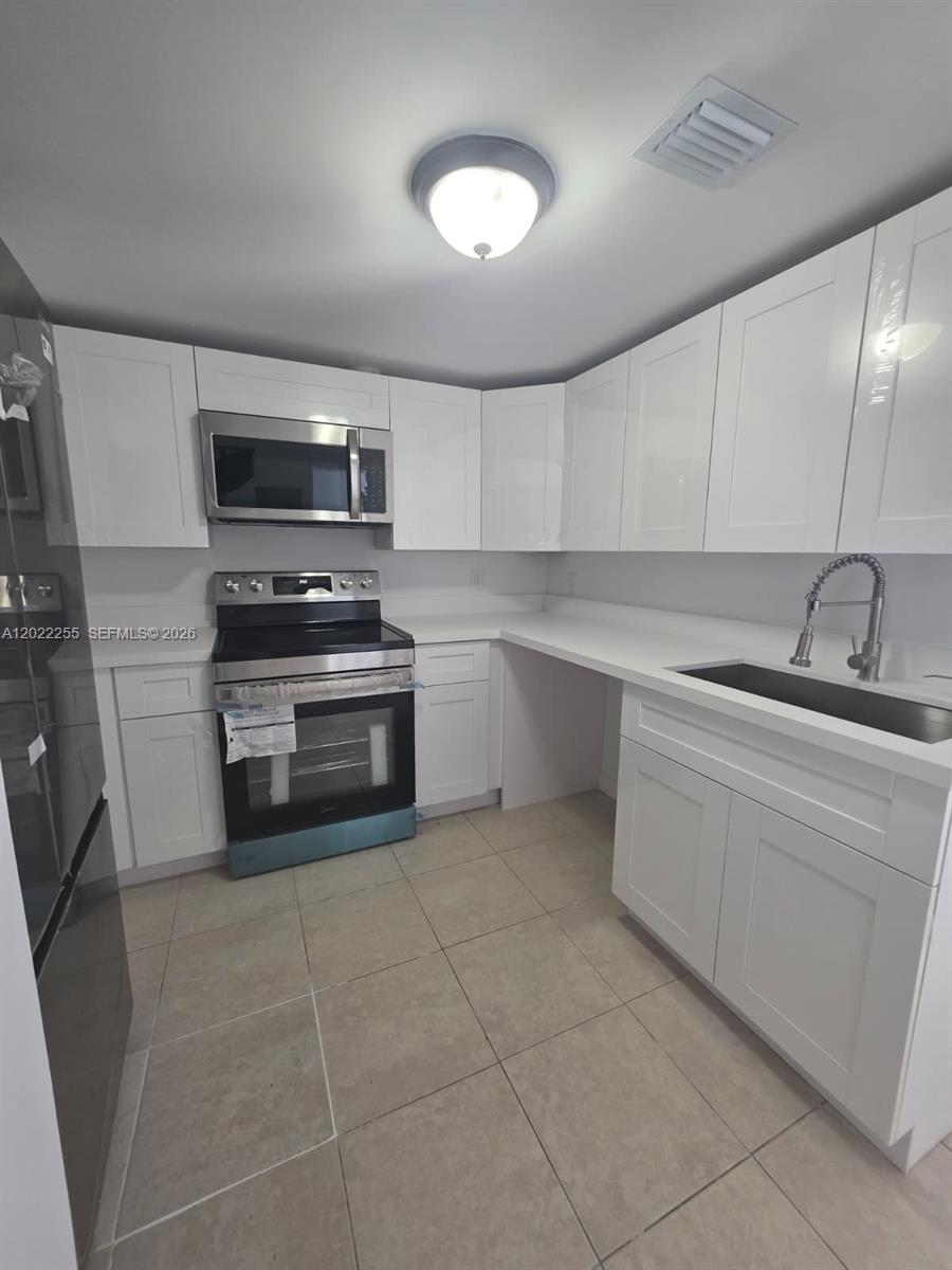 829 Southwest 3rd Street, Unit 831 Miami, FL 33130 - Photo 8 of 21 a kitchen with a sink cabinets and stainless steel appliances