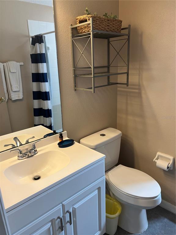 8713 Rockingham Terrace, Unit D Kissimmee, FL 34747 - Photo 11 of 14 a bathroom with a sink a toilet and shower